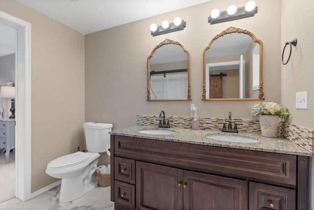 bathroom featuring toilet, vanity, and tasteful backsplash