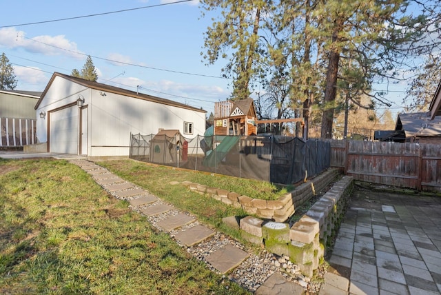 view of yard featuring a playground and a garage