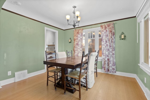 dining space featuring a notable chandelier, plenty of natural light, ornamental molding, and light hardwood / wood-style floors