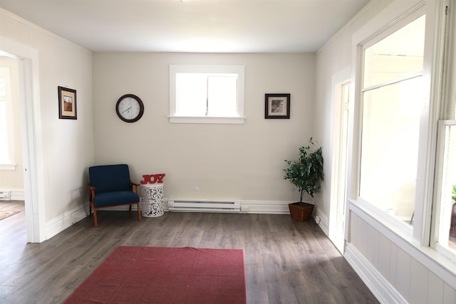 living area with baseboard heating and dark hardwood / wood-style flooring