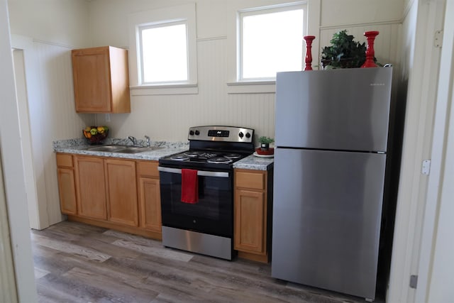 kitchen featuring stainless steel appliances, light hardwood / wood-style flooring, and sink