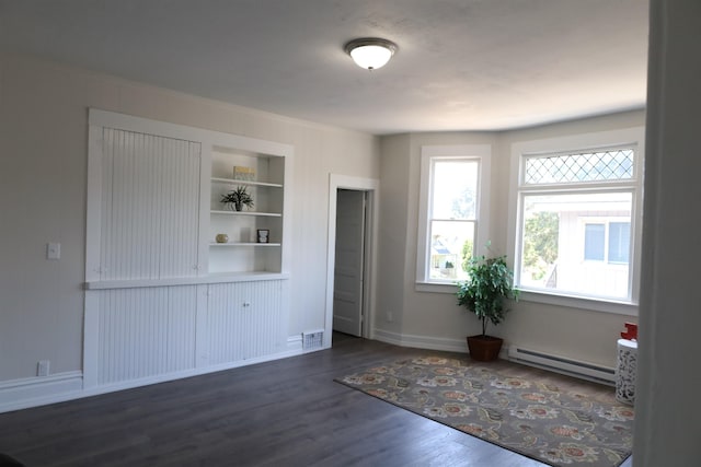 interior space featuring baseboard heating, dark hardwood / wood-style floors, and built in features