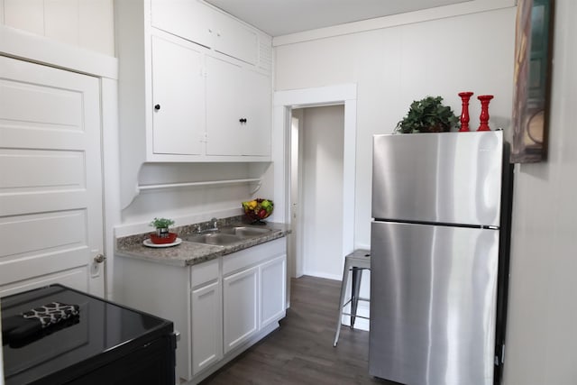 kitchen with dark wood-type flooring, white cabinetry, sink, stainless steel fridge, and electric range