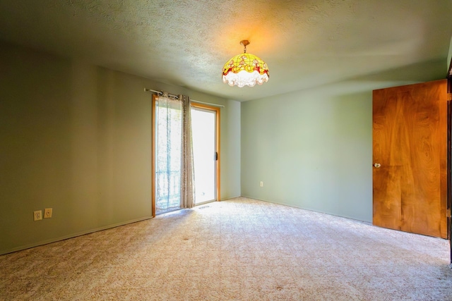 empty room with a textured ceiling and carpet flooring