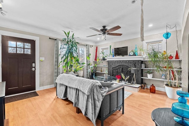 living room featuring hardwood / wood-style flooring, a wealth of natural light, ceiling fan, and a fireplace