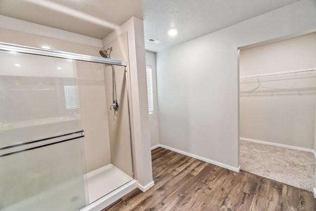 bathroom with hardwood / wood-style floors and an enclosed shower