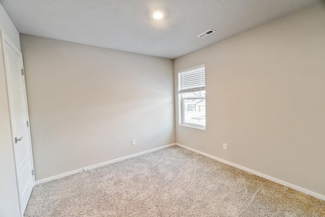 spare room featuring light colored carpet