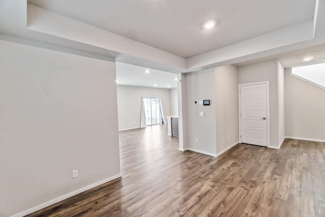 spare room featuring wood-type flooring and a tray ceiling