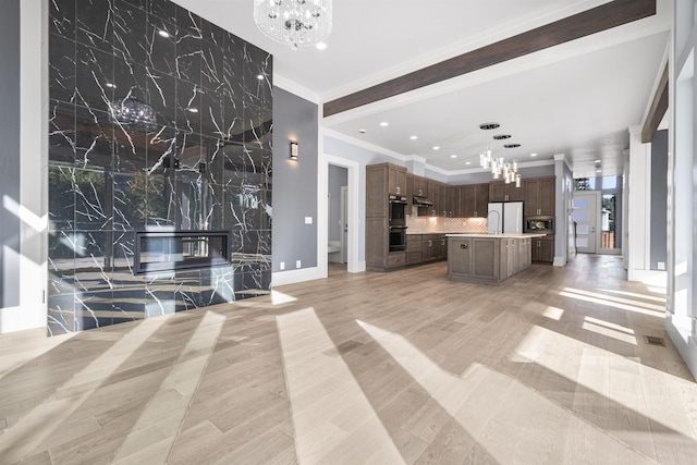 unfurnished living room with a chandelier and ornamental molding