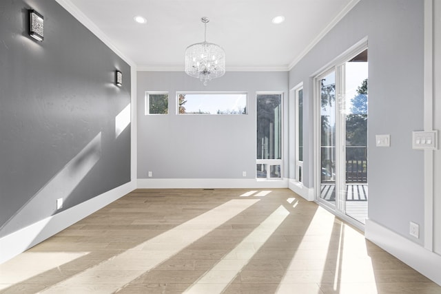 spare room featuring crown molding, light hardwood / wood-style flooring, and a notable chandelier