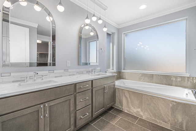 bathroom with ornamental molding, tiled tub, plenty of natural light, and vanity