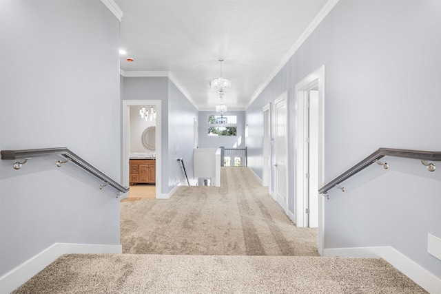 hall featuring light colored carpet, crown molding, and a chandelier