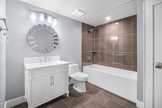 full bathroom with toilet, tiled shower / bath, tile patterned flooring, a textured ceiling, and vanity