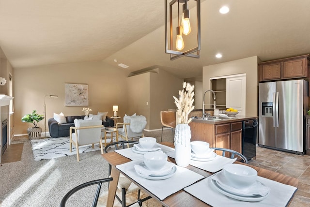 dining area featuring sink and lofted ceiling