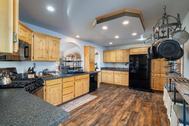 kitchen with light brown cabinetry, sink, dark hardwood / wood-style floors, and black appliances