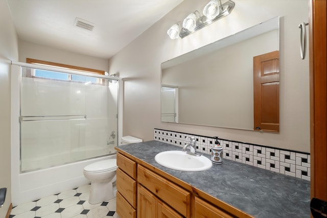 full bathroom featuring toilet, combined bath / shower with glass door, tasteful backsplash, and vanity