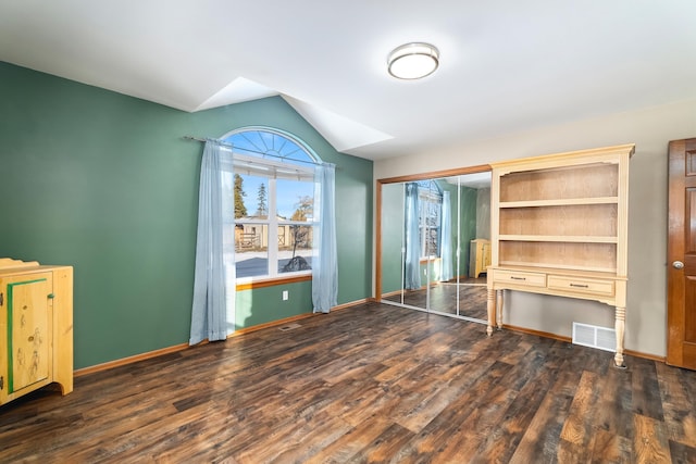 unfurnished bedroom featuring dark hardwood / wood-style floors, a closet, and vaulted ceiling