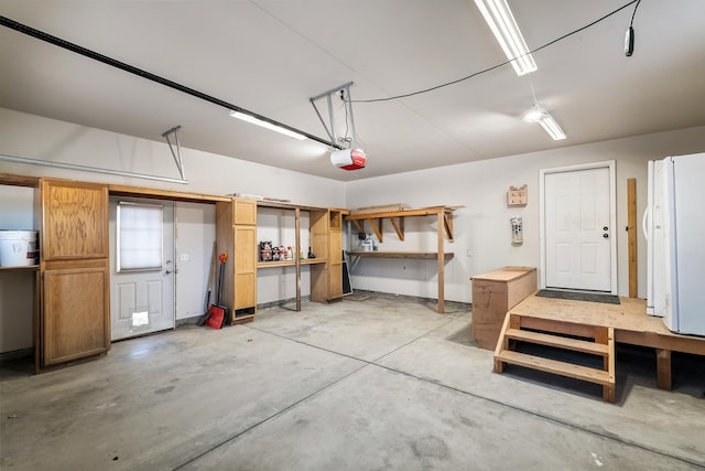 garage with a garage door opener and white refrigerator