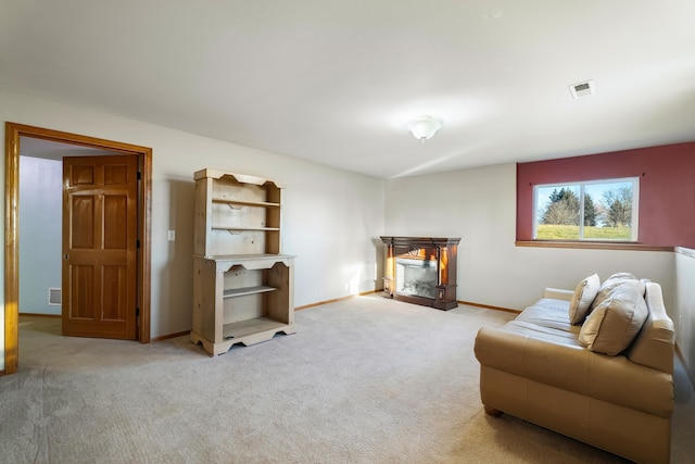 living room featuring light carpet and a fireplace