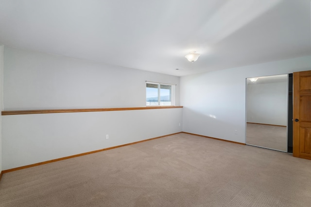 unfurnished room featuring light carpet