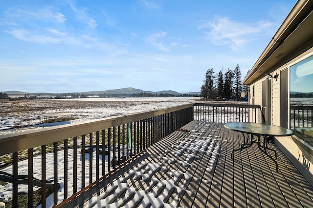 snow covered deck with a mountain view