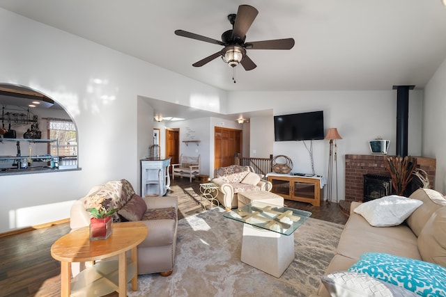 living room featuring ceiling fan, wood-type flooring, vaulted ceiling, and a fireplace