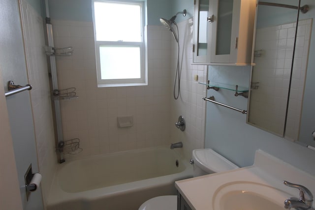 full bathroom with tiled shower / bath combo, toilet, and vanity