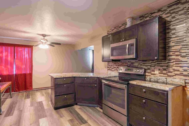 kitchen with backsplash, dark brown cabinets, stainless steel appliances, kitchen peninsula, and light wood-type flooring