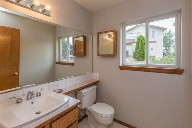 bathroom with backsplash, toilet, and vanity