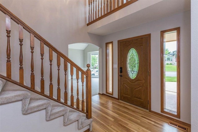 entryway featuring a high ceiling and light hardwood / wood-style floors