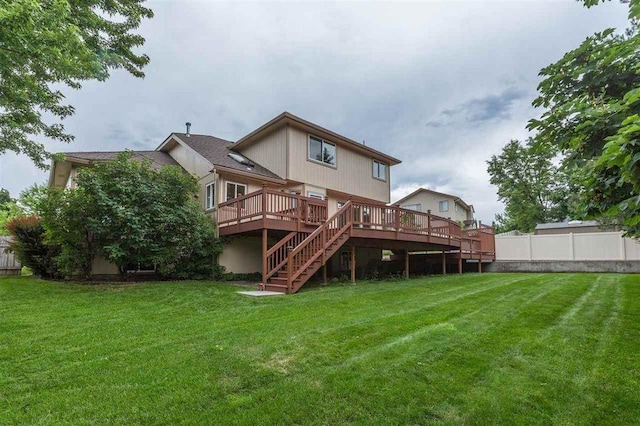 rear view of property featuring a deck and a lawn