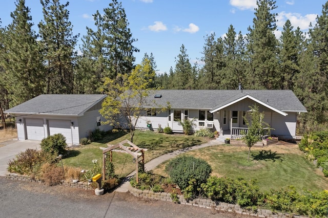 single story home with covered porch, a garage, and a front lawn