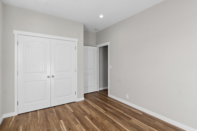 unfurnished bedroom featuring recessed lighting, a closet, baseboards, and wood finished floors