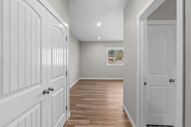 hall with recessed lighting, baseboards, and wood finished floors