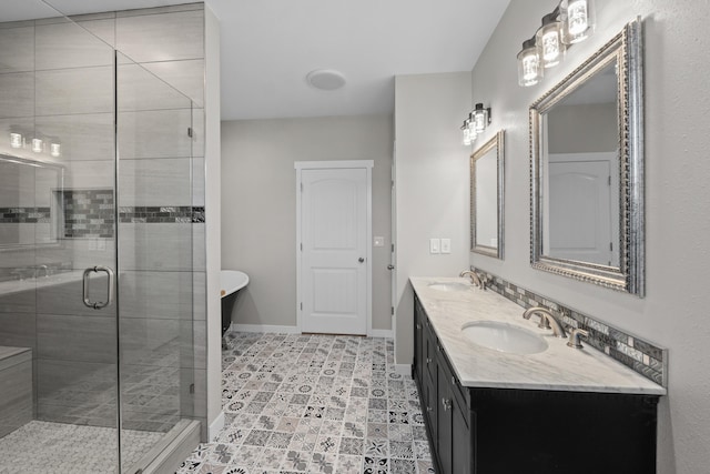 full bath with a sink, baseboards, a freestanding bath, and a stall shower