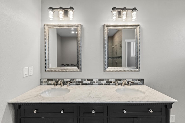 full bath with a sink, double vanity, and a tile shower