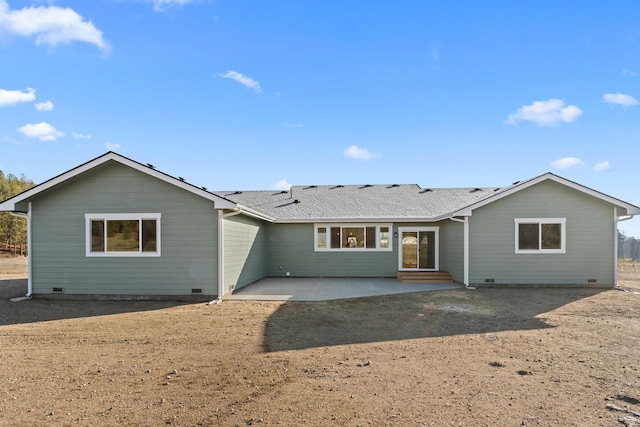 rear view of house with crawl space, a shingled roof, and a patio