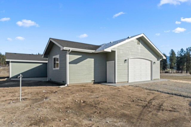 view of side of home with a garage and driveway