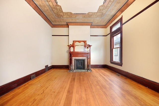 unfurnished living room featuring hardwood / wood-style flooring and ornamental molding