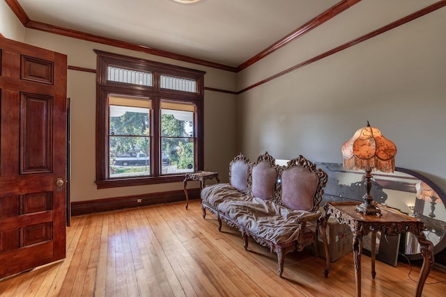 living area with crown molding and light hardwood / wood-style floors