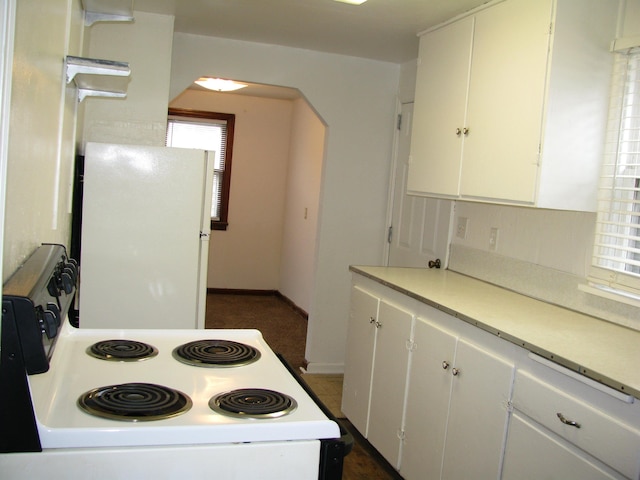 kitchen featuring backsplash, white cabinets, range with electric stovetop, and white fridge