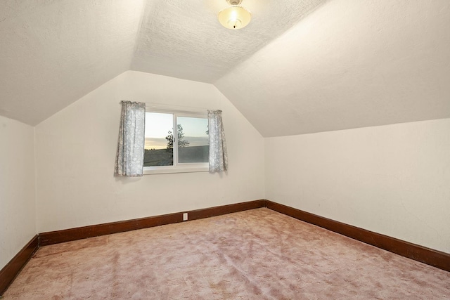 bonus room with a textured ceiling, carpet, and lofted ceiling