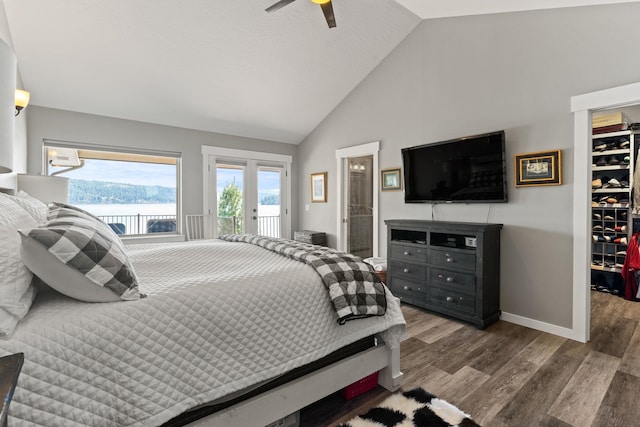 bedroom featuring ceiling fan, lofted ceiling, hardwood / wood-style floors, access to outside, and a walk in closet