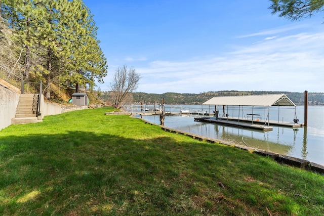 view of dock featuring a water view and a yard