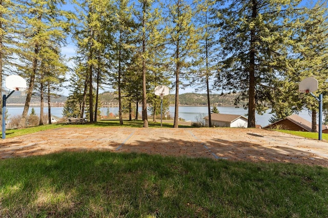 view of yard featuring a water view and basketball court