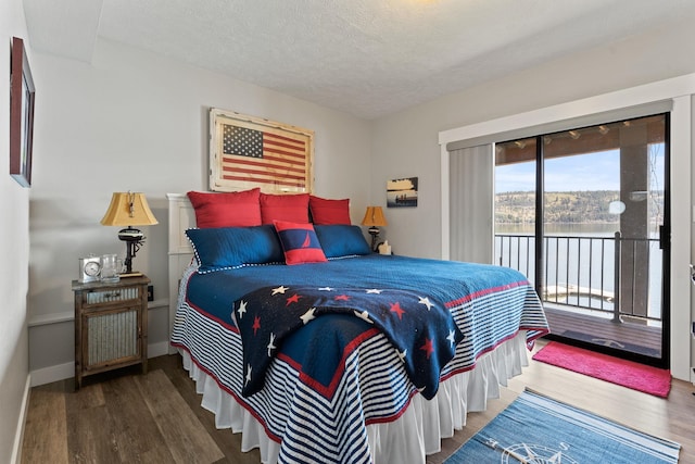 bedroom with hardwood / wood-style flooring, a textured ceiling, and access to outside