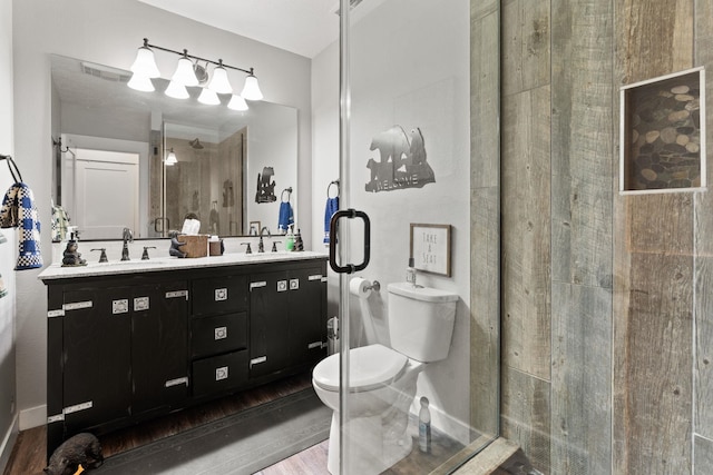 bathroom featuring an enclosed shower, vanity, and toilet