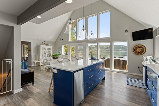 kitchen featuring a kitchen island, wood-type flooring, hanging light fixtures, a kitchen breakfast bar, and blue cabinetry