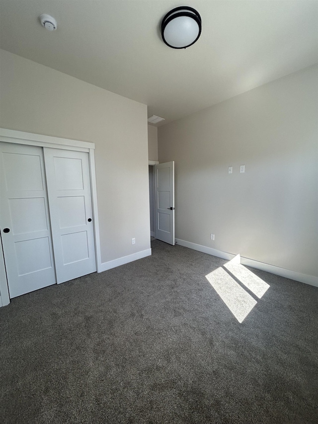 6010 N Windsor St, Spokane, WA 99208 - unfurnished bedroom with baseboards, a closet, and dark carpet
