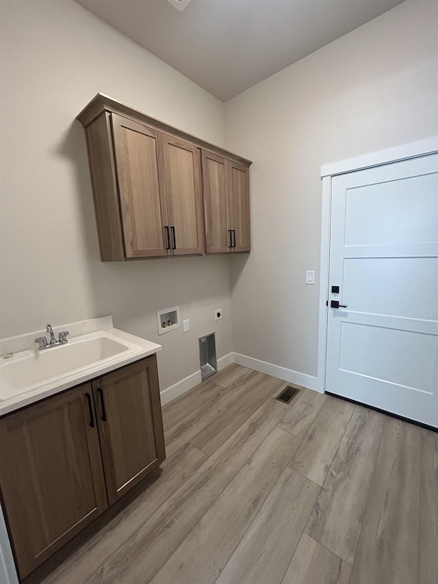 6010 N Windsor St, Spokane, WA 99208 - laundry area featuring hookup for an electric dryer, cabinet space, a sink, hookup for a washing machine, and light wood-style flooring